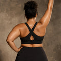 Woman wearing high-strength compression bra in an athletic pose, back view